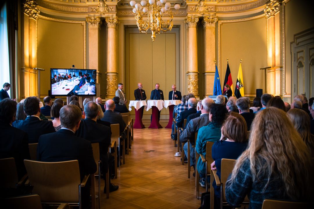 Blick aus dem Publikum auf die Podiumsdiskussion der Veranstaltung
